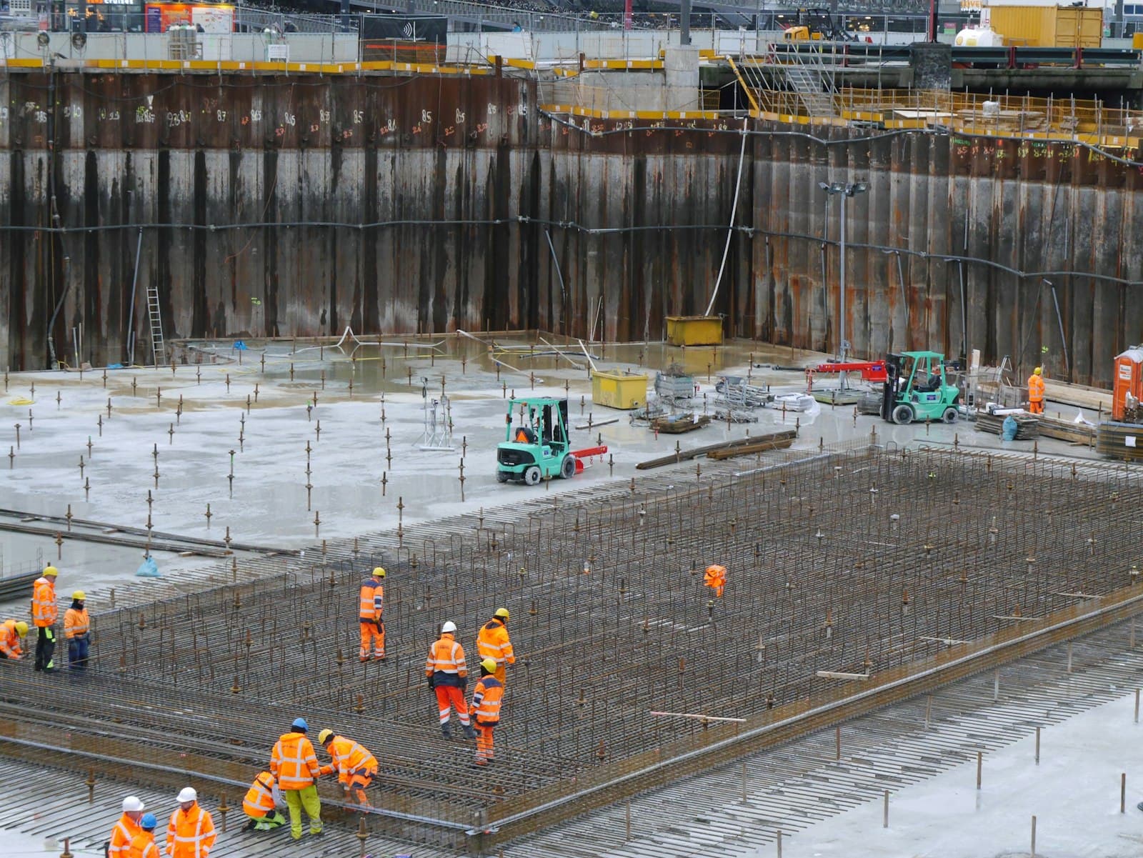 A team of construction workers in hard hats and hi-vis on a building site